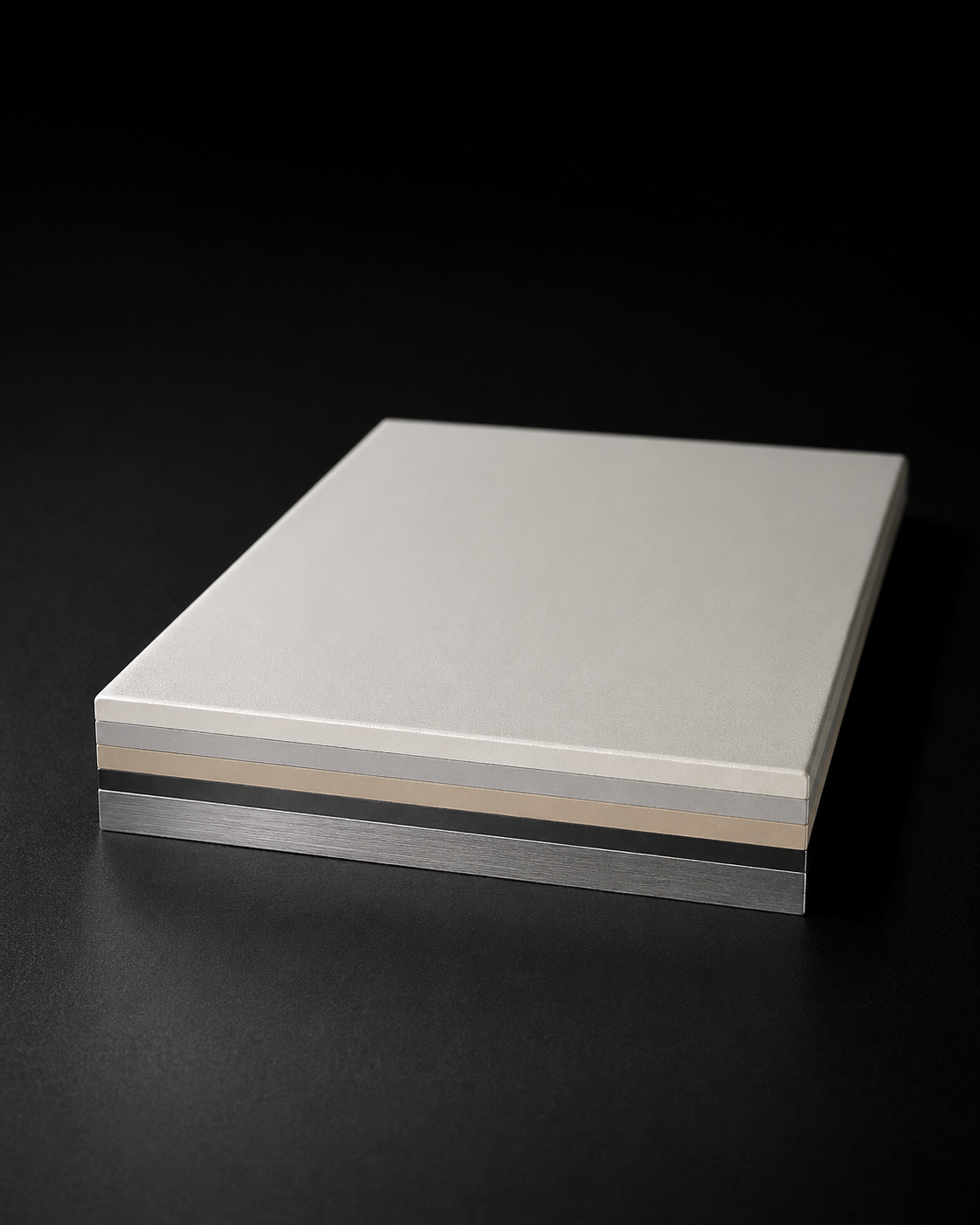 Coated sample with distinct white, bronze, and dark layers visible at the edge, shown against a dark background.