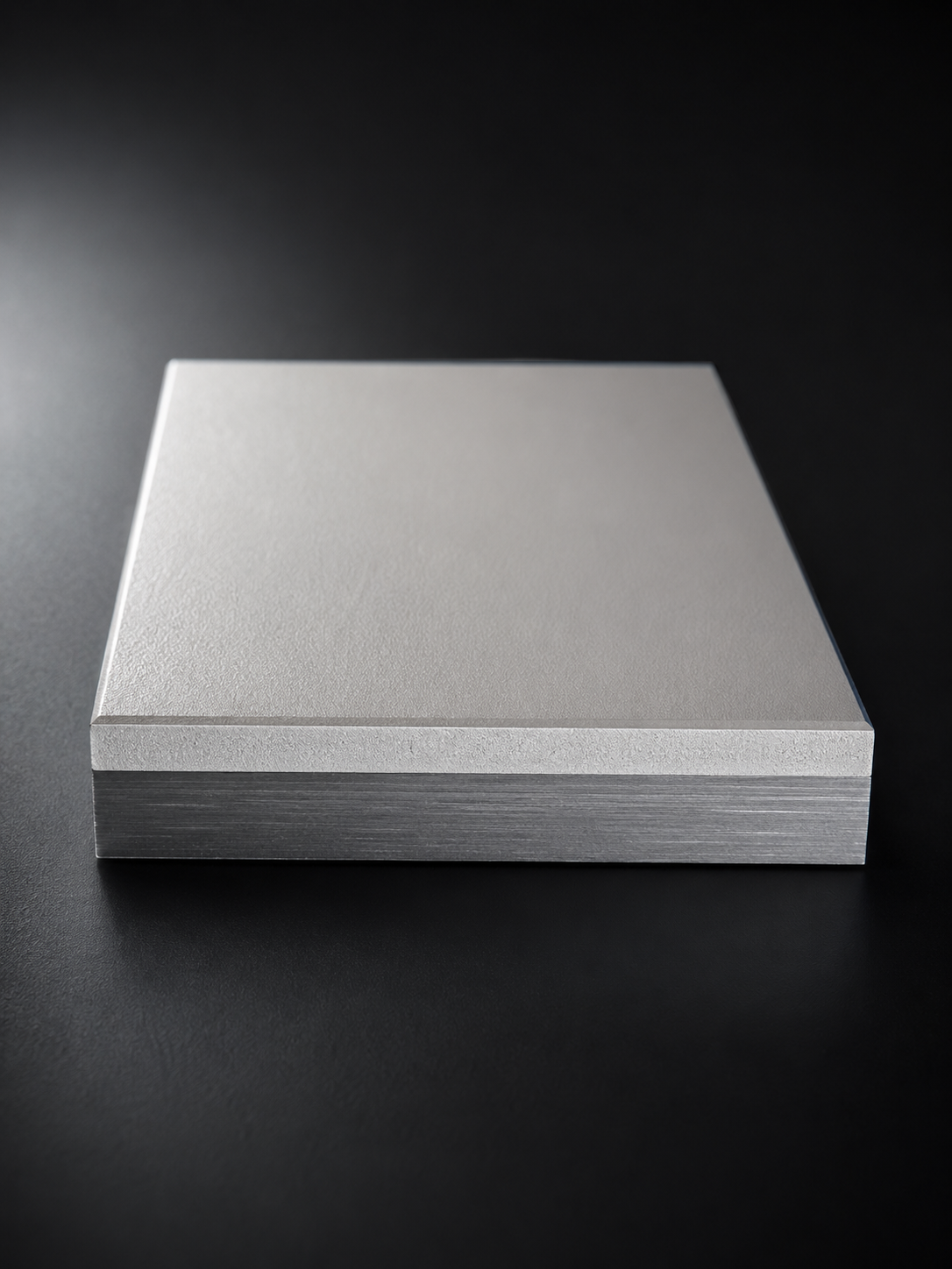 Brushed metal sample plate with a single uniform coating, shown against a dark background.